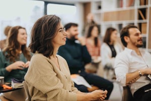Smiling woman participating in a professional workshop_805385696-min